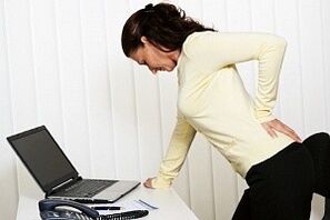 Une femme a mal au dos dans sa région lombaire
